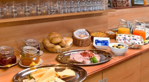 a buffet with plates of food on a table at Hotel Garni Regina in Weerberg