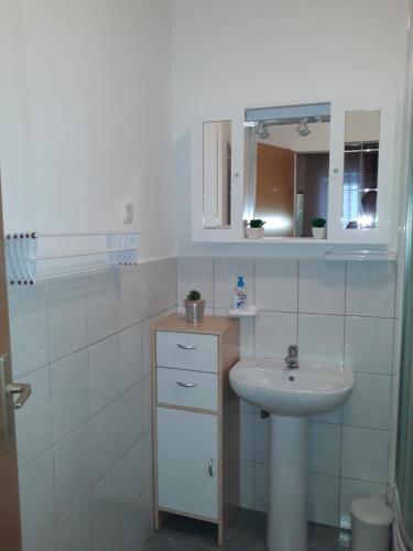 Baño blanco con lavabo y espejo en Apartments & Rooms No.1, en Zadar