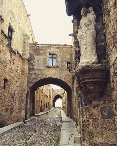 an alley in a castle with a statue of a woman at Rea Hotel in Faliraki