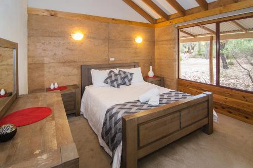 
A bed or beds in a room at Woodstone Grass Tree Cottage
