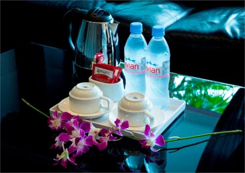 a table with two bottles of water and some flowers at Here Hotel in Skudai