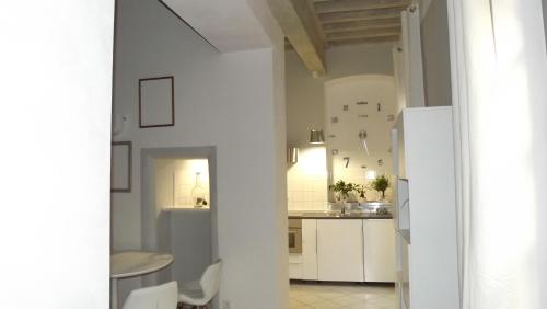 a kitchen with white cabinets and a white refrigerator at Le Barrème in Arles