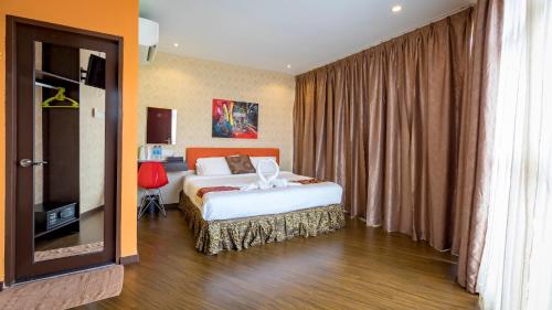 a hotel room with a bed and a television at Hamilton Hotel Kajang in Kajang
