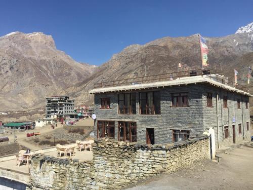 un edificio de piedra frente a una montaña en Himalayan Paradise, en Muktināth