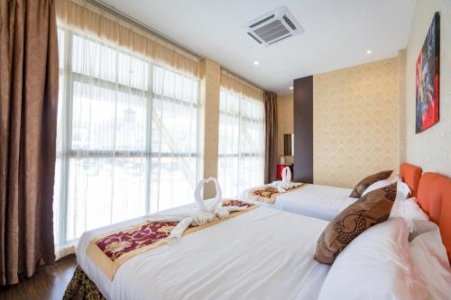 two beds in a room with a large window at Hamilton Hotel Kajang in Kajang