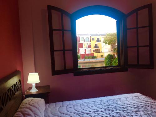 Dormitorio con ventana, cama y lámpara en Port Saplaya - Vistas al mar, en Port Saplaya