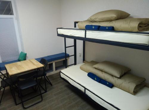 a room with two bunk beds and a table at Hostel Svit Hub in Kamianets-Podilskyi