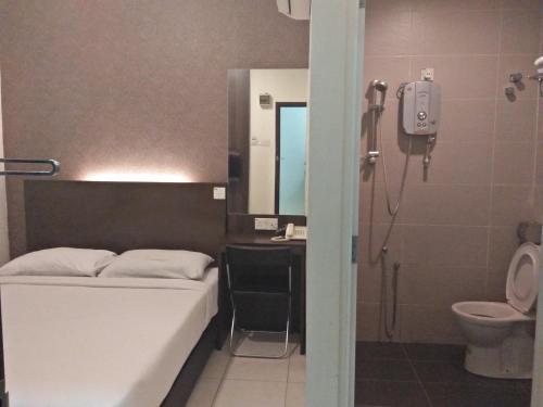 La salle de bains est pourvue d'un lit, d'un lavabo et de toilettes. dans l'établissement The Regency Garden Hotel, à Ipoh