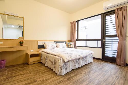 a bedroom with a bed and a large window at Stay My Home in Magong