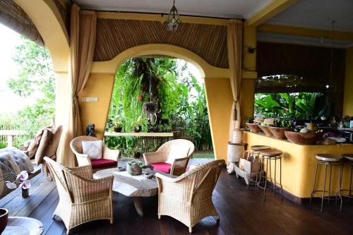 a living room with wicker chairs and a table at DWan Tea Mountain Side in Jatiluwih