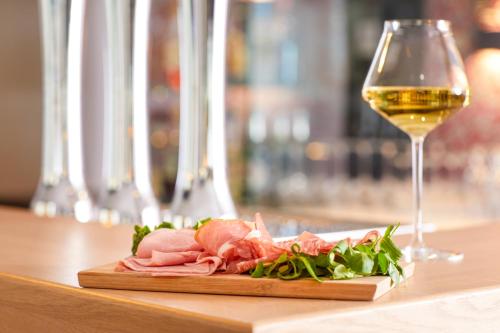 a plate of meat and a glass of wine on a table at Mercure Lyon Centre Plaza République in Lyon