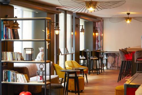a bar with chairs and tables and bookshelves at Mercure Lyon Centre Plaza République in Lyon