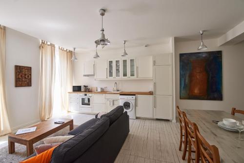 a living room and kitchen with a couch and a table at Bordeaux Village Blaye in Blaye