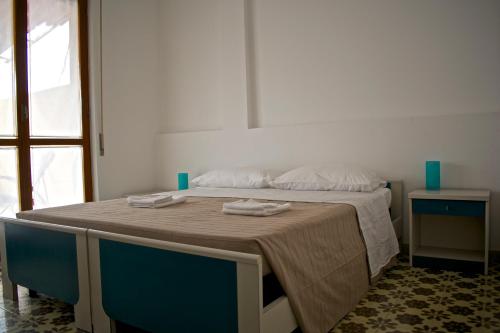 Una cama en una habitación con dos toallas. en Il piccolo attico in centro, en Pozzallo