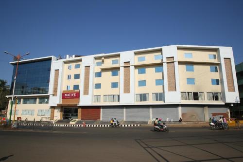a large white building on the side of a street at Native INN By Heda Hospitality in Belgaum