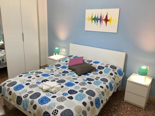 1 dormitorio con 1 cama con paredes azules y 2 lámparas en Vittoria Colonna en Vittoria