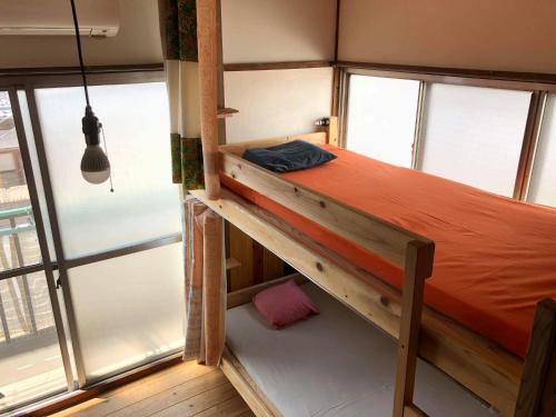 a bunk bed in a room with windows at Fujiya in Matsuyama
