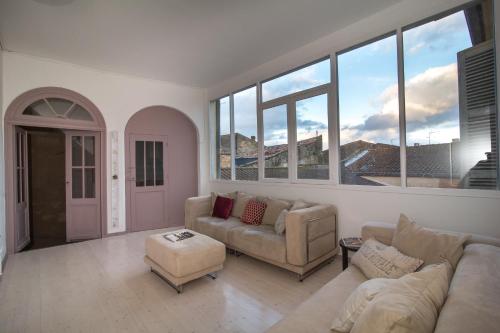 a living room with a couch and chairs and windows at Bordeaux Village Blaye in Blaye