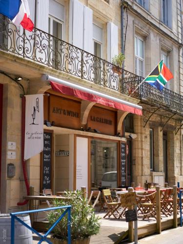 a building with a balcony with a table and a kite at Bordeaux Village Blaye in Blaye