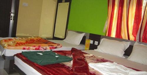two beds sitting next to each other in a room at Hotel Srikrishna International in Tarapith