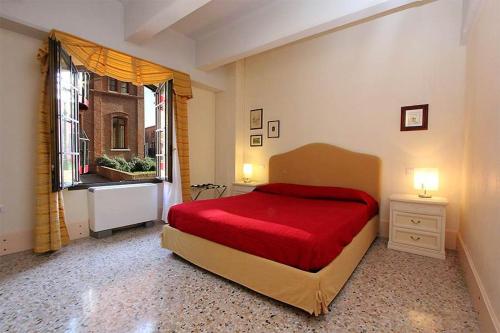 a bedroom with a red bed and a window at Camilla apartment in Venice-Molino in Venice