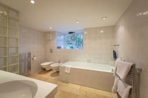 a bathroom with a tub and a toilet and a sink at Grosvenor Villa in Bath