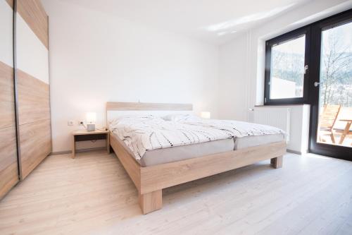 a white bedroom with a bed and a window at Apartment Tiara 2 in Rodine