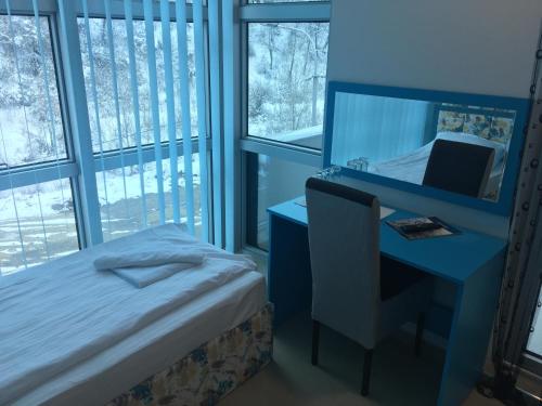 um quarto com uma secretária, uma cama e um espelho em B&B Hisar International em Prijepolje
