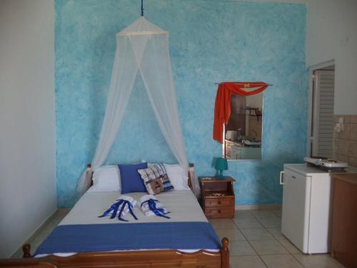 a bedroom with a bed with a blue wall at Studios Avra in Akhladherí