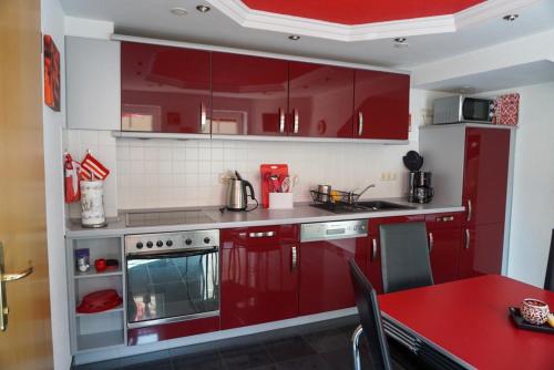 バート・シャンダウにあるFerienwohnung Albrecht Sonnendeckの赤いキャビネットと赤いテーブル付きの赤いキッチン