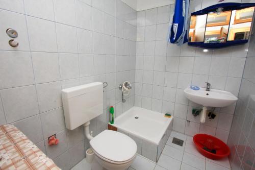 a small bathroom with a toilet and a sink at Robinson Torac in Gdinj