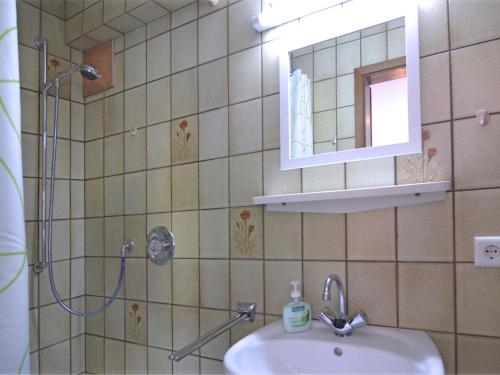 ein Bad mit einem Waschbecken, einem Spiegel und einer Dusche in der Unterkunft Modern Apartment in Sellinghausen with Terrace in Schmallenberg