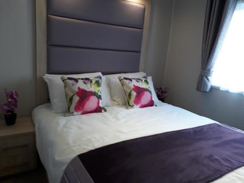 A bed or beds in a room at Aspen Retreat, Haggerston Castle