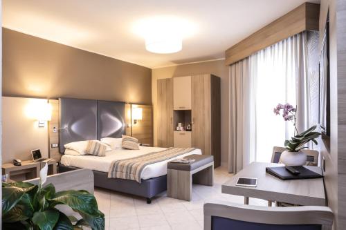 a hotel room with a bed and a desk at Alma di Alghero Hotel in Alghero