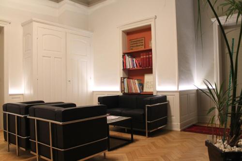a living room with two chairs and a book shelf at Villa Élyane in Colmar