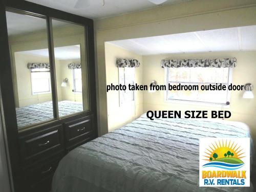 - une chambre avec un lit et un grand miroir dans l'établissement Boardwalk RV Rental (Site #13), à Cavendish