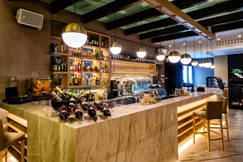 a bar in a restaurant with a counter and lights at Nafs Hotel in Nafpaktos