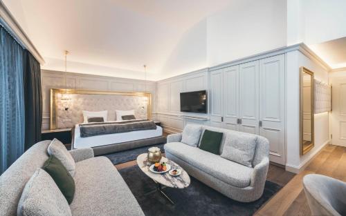 a large living room with a bed and a couch at Schlosshotel Ischgl 5-Sterne Superior in Ischgl