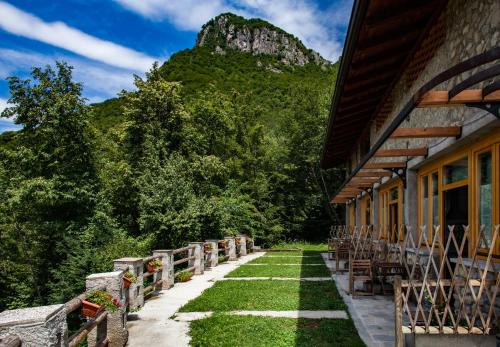 a building with chairs and a mountain in the background at Agriturismo La Selvaggia in Mandello del Lario