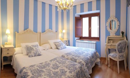 1 dormitorio con 2 camas con rayas azules y blancas en Legado de Ugarte, Casa Rural en Laguardia