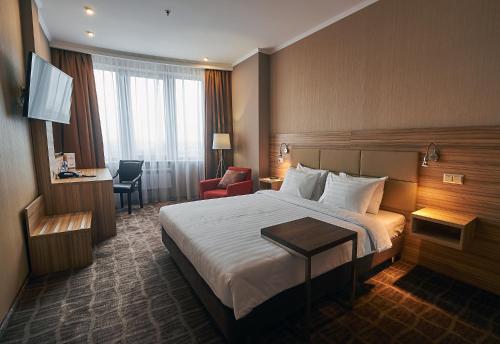 een hotelkamer met een bed en een bureau bij Ramada by Wyndham Rostov-on-Don Hotel and Spa in Rostov aan de Don