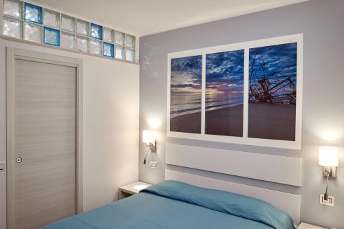 a bedroom with a blue bed and two windows at Best Vasto in Vasto