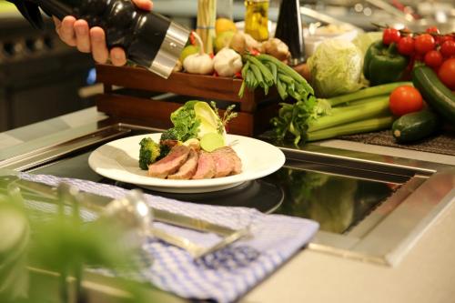 a counter with a plate of meat and vegetables at H4 Hotel Leipzig in Leipzig