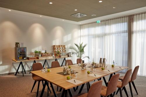 a conference room with a long table and chairs at H4 Hotel Leipzig in Leipzig