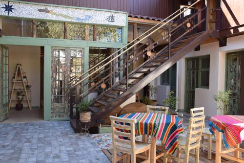 un patio con una escalera en una casa con mesa y sillas en Eco-Hostal Tambo Verde, en Santiago