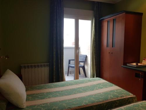 a bedroom with a bed and a window with a chair at Idh Angel in Oviedo