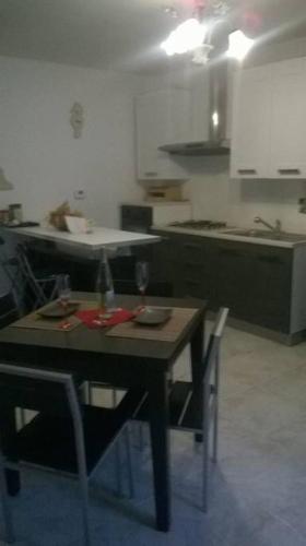 a kitchen with a wooden table with chairs and a table and a table at !!!OFFERTA LAST MINUTE!!! 300m dalla spiaggia in Torre Lapillo