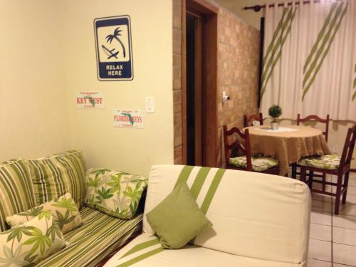 una sala de estar con sofá y un cartel en la pared en Condomínio Solar dos Reis, en Florianópolis