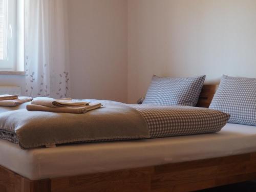 a bed with two pillows on top of it at Haflingerhof Appenstein in Pinswang