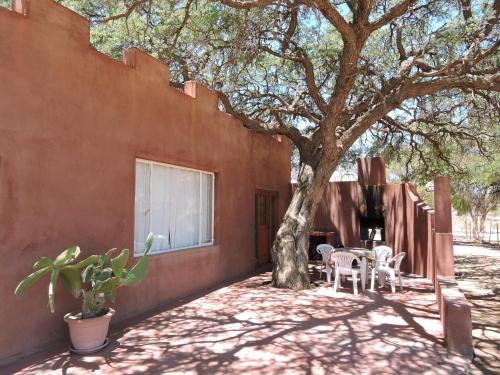 a patio with a tree and a table and chairs at Savanna Guest Farm in Grünau